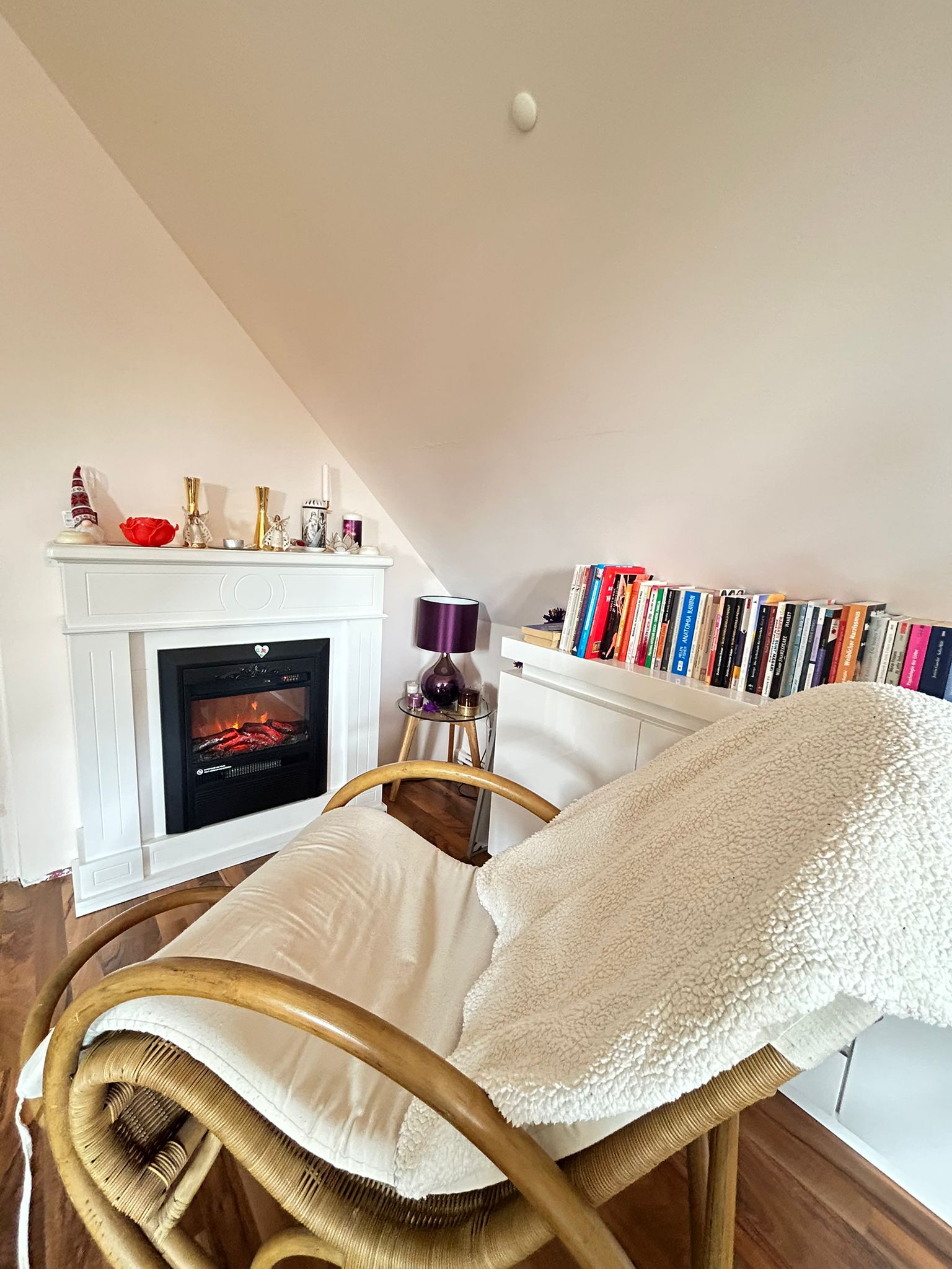 Gemütlicher Warte- und Rückzugsbereich in der Praxis mit Sessel, Kamin und ruhiger Atmosphäre